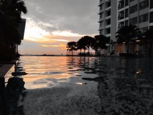 a view of a pool of water at sunset at Sara Staycation in Kajang