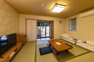 a living room with a couch and a table at ETAVIA Yufuin Kinrinko in Yufu