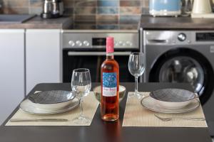 una bottiglia di vino seduta su un tavolo con due bicchieri di On The Breeze 1 a Città di Kos