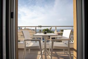 un tavolo e sedie su un balcone con vista sull'oceano di On The Breeze 1 a Città di Kos