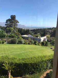 a green field with a house in the background at Wine Cottage by the Sea in Helderberg