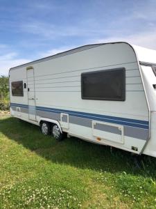 ein weißer Anhänger auf einem Feld parkt in der Unterkunft Mobilheimy Dlouhá Míle in Rožmitál pod Třemšínem