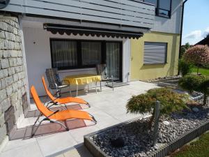 a patio with two chairs and a table on it at Ferienwohnung Piller 4 Sterne in Michelsneukirchen