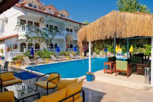 un complexe avec une piscine, des chaises et un bâtiment dans l'établissement Casablanca Hotel, à Dalyan