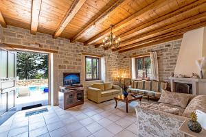 uma grande sala de estar com uma parede de pedra em Villa Despina em Prinés