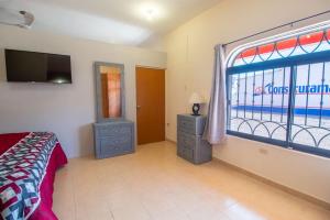 サン・カルロスにあるHacienda Gallardos 104-4のベッドルーム(ベッド1台、窓、テレビ付)