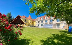 a building with a yard with grass and flowers at Villa Park Panzió in Szilvásvárad