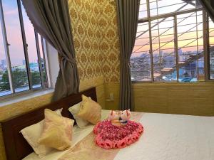ein Schlafzimmer mit einem Bett mit Kuchen drauf in der Unterkunft ĐÔNG NAM HOTEL CẦN THƠ in Cần Thơ