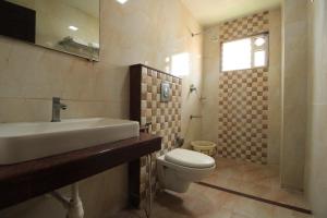 a bathroom with a sink and a toilet at Pondy Southern Residency in Puducherry