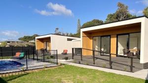 a house with a patio and a swimming pool at Ohope Villas with Spa,Sauna,Pool, Adults Only in Ohope Beach