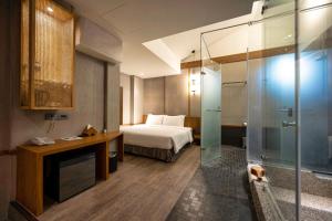 una camera d'albergo con letto e doccia in vetro di Yunoyado Onsen Hot Spring Hotel Deyang a Jiaoxi