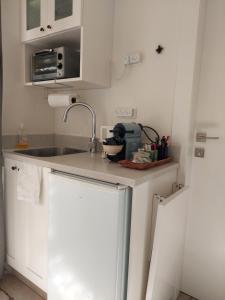 a small kitchen with white cabinets and a sink at Legatia in Jerusalem