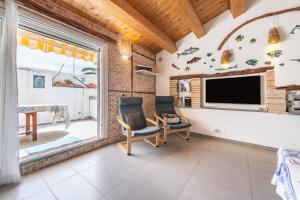 Casa Saliu في كارلوفورتي: غرفة معيشة مع كرسيين وتلفزيون بشاشة مسطحة