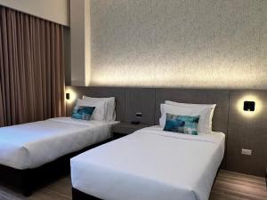 una habitación de hotel con 2 camas en una habitación en The Litton Hotel by Carterson, en Naga