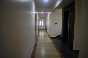 un corridoio con pareti bianche e pavimento in legno di Hotel Pauwa Pokhara a Pokhara