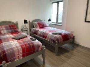 two beds sitting next to each other in a bedroom at Rooms in Inverness in Inverness