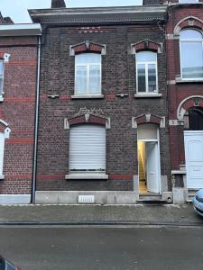 a brick building with white garage doors on a street at Grande maison avec plusieurs chambres à louer in Liège
