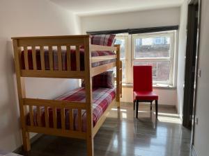 a bedroom with two bunk beds and a red chair at Rooms in Inverness in Inverness