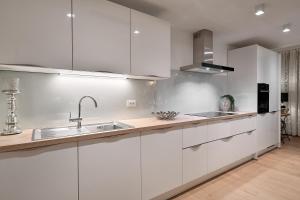 una cocina con armarios blancos y fregadero en K luxury residence en Split