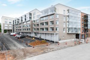 an image of an apartment building with a parking lot at Hiisi Homes Hämeenlinna Asemanranta in Hämeenlinna