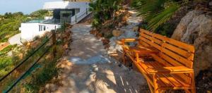 a wooden bench sitting on the side of a hill at Villa El Buzo in Zahara de los Atunes