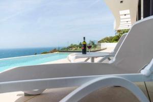 a bottle of wine sitting on a table next to a pool at Villa El Buzo in Zahara de los Atunes