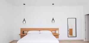 a bedroom with a white bed and a mirror at Villa El Buzo in Zahara de los Atunes