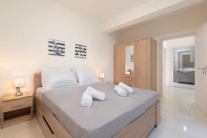 1 dormitorio con 1 cama grande con almohadas blancas en Asterashouse en Rodas