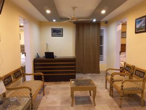 a living room with chairs and a table and a desk at Ringachan Guest House & Restaurant in Skardu