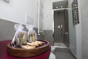 - un plateau avec des bouteilles de savon et de fromage dans la salle de bains dans l'établissement SuDaNoi, à Bari