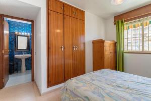 a bedroom with a bed and a bathroom with a sink at Casa La Roqueta in Guardamar del Segura