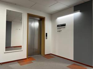 a hallway with a elevator and a sign on a wall at UCU INN - Кімнати для гостей in Lviv