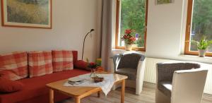 een woonkamer met een bank en een tafel en stoelen bij Ferienwohnung Gerlach in Thale
