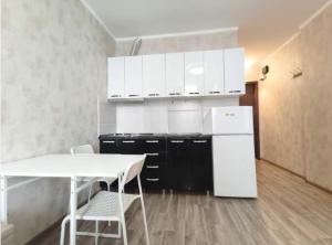 a kitchen with a white refrigerator and a table and chairs at Apartment in Orbi Sea Tower in Batumi