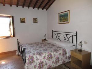 1 dormitorio con cama y ventana en Agriturismo Podere Cappella, en San Gimignano