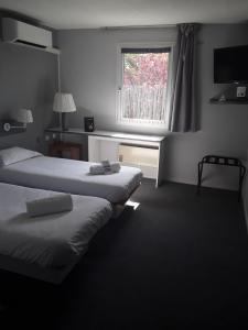 A bed or beds in a room at Contact Hôtel ALYS Bourg en Bresse Ekinox Parc Expo