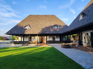 ein großes Haus mit einem großen Rasenplatz in der Unterkunft Ograda Bunicilor in Baia de Fier