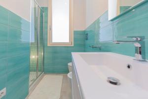a bathroom with a tub and a toilet and a window at Appartamento La Triglia - HelloElba in Lacona +22 photos