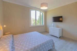a bedroom with a bed and a tv on the wall at Appartamento La Triglia - HelloElba in Lacona