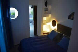Un dormitorio con una cama azul y una ventana en EL REFUGIO, en Famara