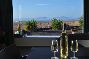 法马拉EL REFUGIO的桌上放着一瓶葡萄酒，旁边还有两个酒杯