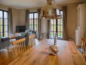 ein Esszimmer und ein Wohnzimmer mit einem großen Holztisch in der Unterkunft Reetland am Meer - Superior Reetdachvilla mit 2 Schlafzimmern F02 in Dranske