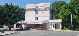 a building with a sign on the side of it at Hotel Proton in Neptun