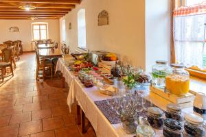 un grupo de mesas largas con comida y bebidas. en Althanský hostinec, en Znojmo