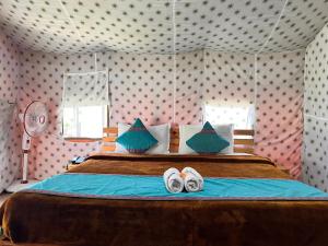 Un dormitorio con una cama con dos zapatos. en North Deodar Camps, en Kasol
