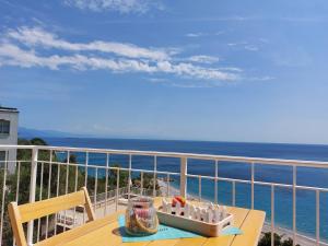 a table on a balcony with a view of the ocean at Una finestra sul mare Home 1 in Bergeggi