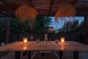 un tavolo in legno con candele e bicchieri da vino su un patio di Villa Fio a Fiorini