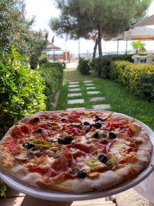 a pizza sitting on a plate on a table at RUMAR HOTEL in Durrës