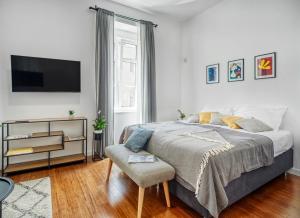 a bedroom with a bed and a tv and a chair at Berry Berry Studios by Flat White in Zagreb
