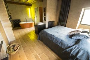 ein Schlafzimmer mit Bett, Badewanne und Badezimmer in der Unterkunft Consolación in Monroyo